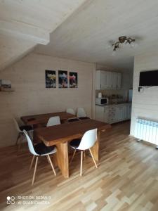 een eetkamer met een houten tafel en stoelen bij Nota Bene Mykulychyn in Mykulychyn