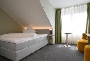 um quarto de hotel com uma cama e uma janela em Hotel Restaurant Zur Post Lohfelden em Kassel