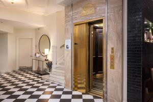 una hall con porta d'oro e pavimento a scacchi di Copley Square Hotel, a FOUND Hotel a Boston