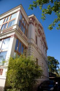 a white building with a tree in front of it at Appartementhaus Witzmann in Bad Vöslau