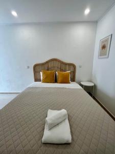 a bedroom with a large bed with yellow pillows at Galagana Charm House in Golegã