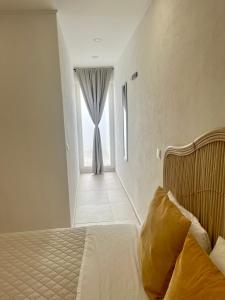 a bedroom with a bed and a window with a curtain at Galagana Charm House in Golegã