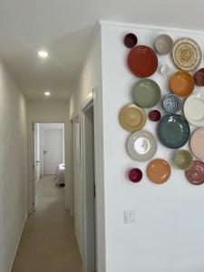 a wall filled with different colored plates on a wall at Galagana Charm House in Golegã