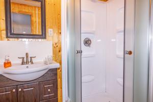 a bathroom with a sink and a shower at Gite la Maison Rochefort in Baie-Sainte-Catherine