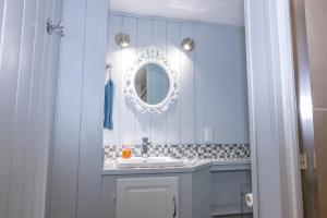 a bathroom with a sink and a mirror at Gite la Maison Rochefort in Baie-Sainte-Catherine