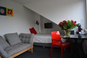 - un salon avec un canapé, une table et un lit dans l'établissement Guesthouse de Hoogkamp, à Arnhem