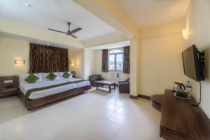 a bedroom with a bed and a flat screen tv at Treebo Green Park in Mapusa