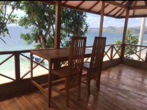 un tavolo in legno con sedie su un balcone con vista sull'oceano di Gili Gede Homestay a Gili Gede