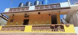 ein gelbes und weißes Gebäude mit einem Balkon in der Unterkunft Kmt green house ooty in Udagamandalam