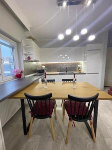 une cuisine avec une table en bois et deux chaises dans l'établissement House Thalassa, à Peraia