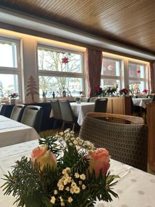 una sala da pranzo con tavoli e fiori sul tavolo di Hotel Berliner Hof a Braunlage