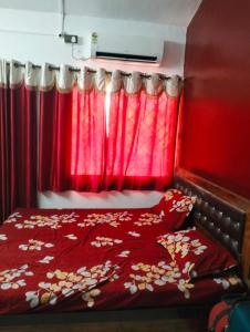 1 dormitorio rojo con 1 cama con cortina roja en shirley cottage, en Daulatābād