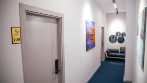 a hallway with a white door and a blue carpet at Hotel Dirista in Shkodër