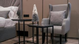 a bedroom with a chair and a table with a christmas tree at Hotel Dirista in Shkodër