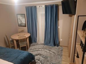 - une chambre avec une table et un rideau bleu dans l'établissement Hostel Anton, à Tivat