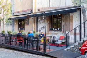 een groep mensen aan een tafel buiten een restaurant bij Hotel Bohemian Garni - Skadarlija in Belgrado