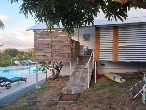 a house with a staircase next to a swimming pool at Residence Ma Vie Là Ltee in Le Morne