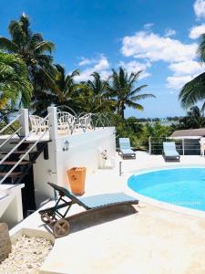 a villa with a swimming pool and palm trees at Residence Ma Vie Là Ltee in Le Morne