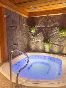 een jacuzzi in een kamer met een stenen muur bij Wellness Penzion Zora Family in Tatranská Lomnica