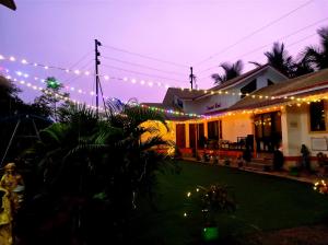 une maison avec des lumières de Noël allumées la nuit dans l'établissement Suncrest Wood Stayz, à Alibaug