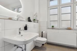 een witte badkamer met een wastafel en een toilet bij maremar - Verden's Finest - 134qm - 2 Schlafzimmer - Luxus Boxspring - Küche - Terrasse - Arbeitsplätze & Highspeed WLAN in Verden