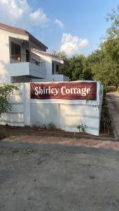 un edificio con una señal para un contenedor de transporte en shirley cottage, en Daulatābād