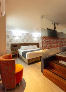 a bedroom with a bed and a mirror and a chair at Zi One Luxury Hotel in Pereira