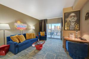 un soggiorno con divano blu e tavolo di SPHERE IN HD! - 1BR Private Retro Condo With PREMIUM Views a Las Vegas