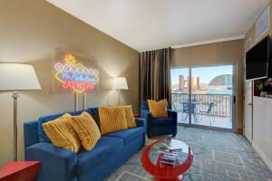 un soggiorno con divano blu in una camera d'albergo di SPHERE IN HD! - 1BR Private Retro Condo With PREMIUM Views a Las Vegas