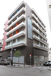 een gebouw in een straat waar auto's voor geparkeerd staan bij Aliakmon Hotel in Kozani