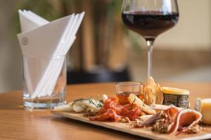 une assiette de nourriture et un verre de vin sur une table dans l'établissement Sheraton Cascais Resort - Hotel & Residences, à Cascais