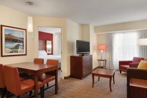 ein Wohnzimmer mit einem Zimmer mit einem Bett und einem TV in der Unterkunft Residence Inn by Marriott Newport Middletown in Middletown