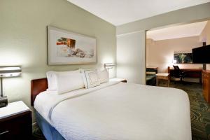 リンティカム・ハイツにあるSpringHill Suites by Marriott Baltimore BWI Airportの大きなベッドとデスクが備わるホテルルームです。