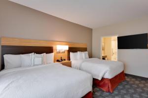 TownePlace Suites by Marriott Detroit Allen Park tesisinde bir odada yatak veya yataklar