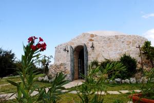 ein kleines Steingebäude mit einer Tür im Garten in der Unterkunft Hotel Incanto in Ostuni