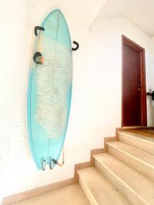 una tavola da surf appesa a un muro accanto a una porta di Beach Lovers Surf House - Aveiro - Praia da Barra a Praia da Barra