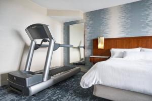 a hotel room with a treadmill next to a bed at The Westin Virginia Beach Town Center in Virginia Beach