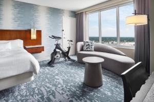 a hotel room with a bed and a couch and a bike at The Westin Virginia Beach Town Center in Virginia Beach