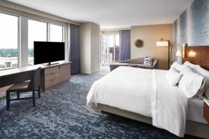 a hotel room with a bed and a desk and a television at The Westin Virginia Beach Town Center in Virginia Beach