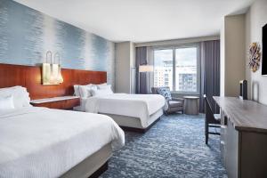 a hotel room with two beds and a television at The Westin Virginia Beach Town Center in Virginia Beach