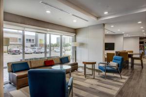 休斯顿TownePlace Suites by Marriott Houston Hobby Airport的大堂配有沙发、椅子和桌子