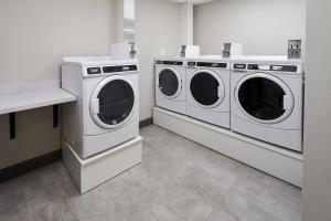 two washing machines and a counter in a laundry room at TownePlace Suites by Marriott Hamilton in Hamilton