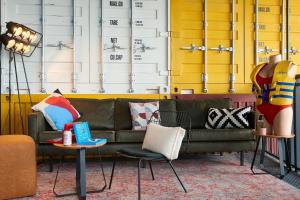 a living room with a couch and two tables with pillows at Moxy Southampton in Southampton