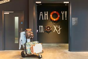 a room with a luggage cart in front of a door at Moxy Southampton in Southampton