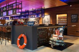 a bar with an orange sign next to a counter at Moxy Southampton in Southampton