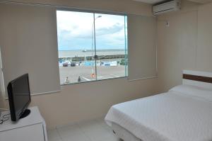 Schlafzimmer mit einem Bett und einem Fenster mit Meerblick in der Unterkunft Amazon Plaza Hotel Ltda in Macapá