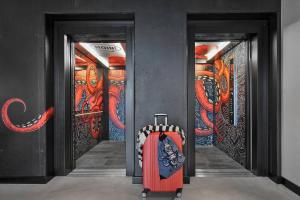 a suitcase in a hallway with graffiti on the walls at Moxy Bremen in Bremen