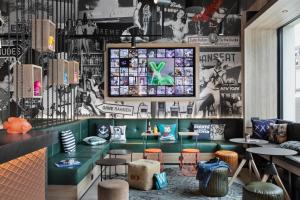 a restaurant with a green counter and stools at Moxy Bremen in Bremen