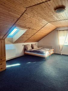 una camera con letto in una stanza con soffitti in legno di Penzion Berany a Jablonec nad Nisou