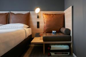 a bedroom with a bed and a table with a chair at Moxy Sophia Antipolis in Biot